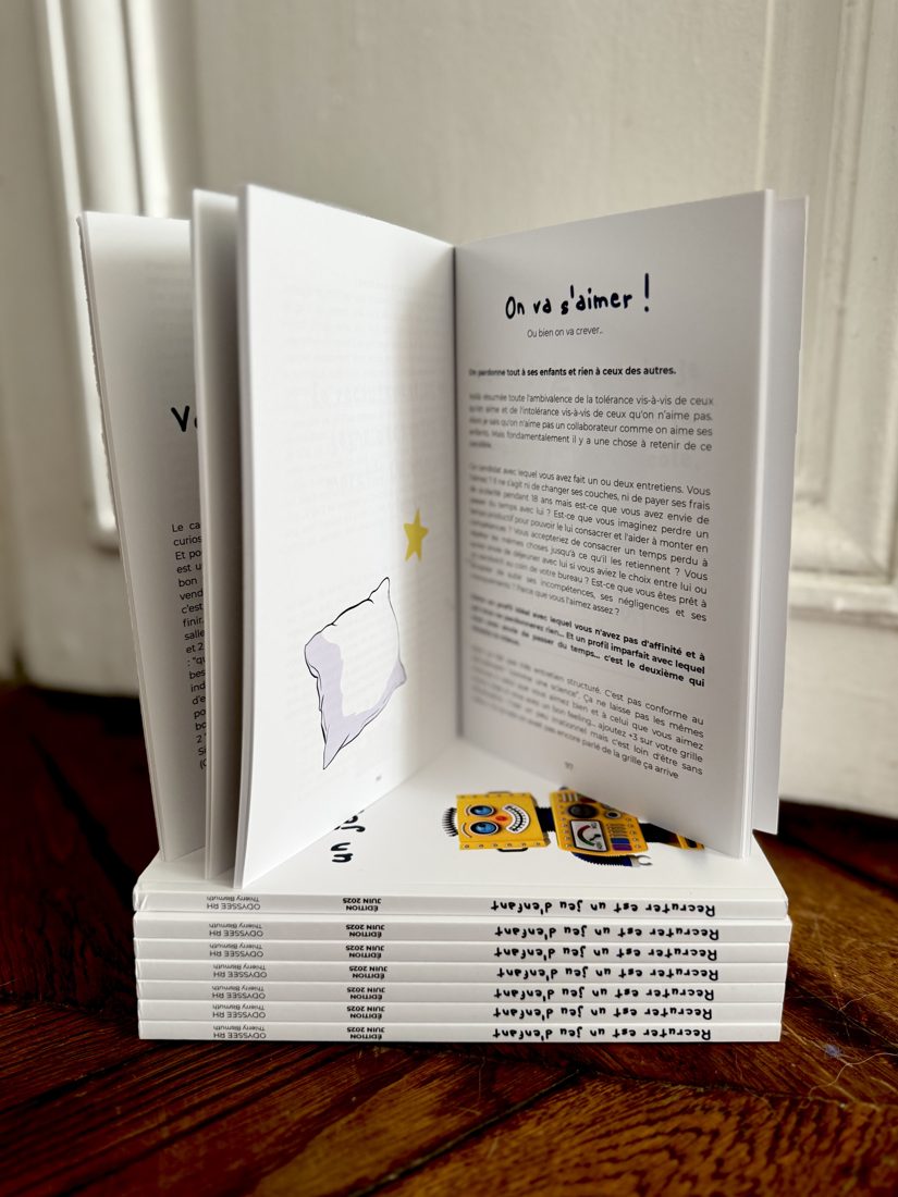 Le livre Recruter est un jeu d'enfant ouvert sur une pile d'exemplaires